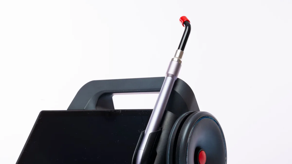 Close-up of a dental laser machine with a screen and handpiece, showcasing modern medical technology.
